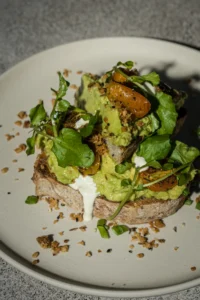 Smashed avocado toast with blistered cherry tomatoes and watercress at Dawn cafe Lago