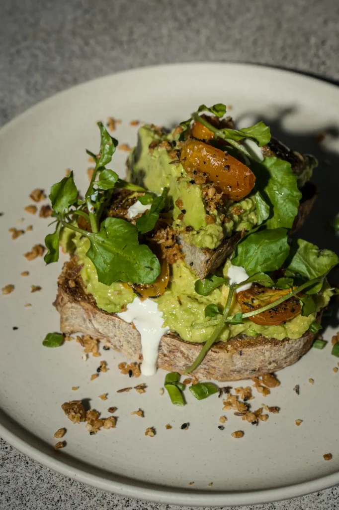 Smashed avocado toast with blistered cherry tomatoes and watercress at Dawn cafe Lago
